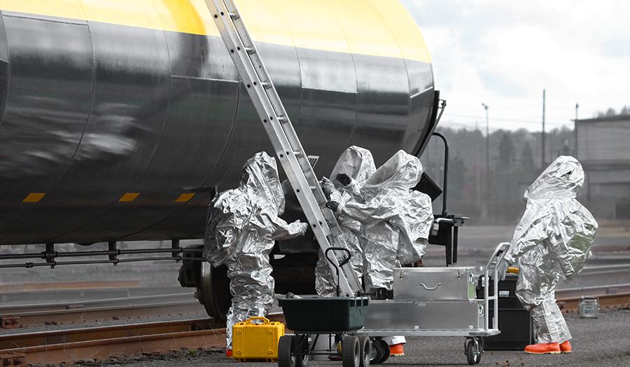 CBRN Detection in One Compact Package. Hazmat team approaching a freight train.